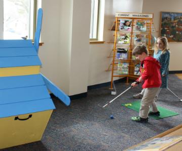 Color photograph of two young children putting in the Woodstock Public Library.