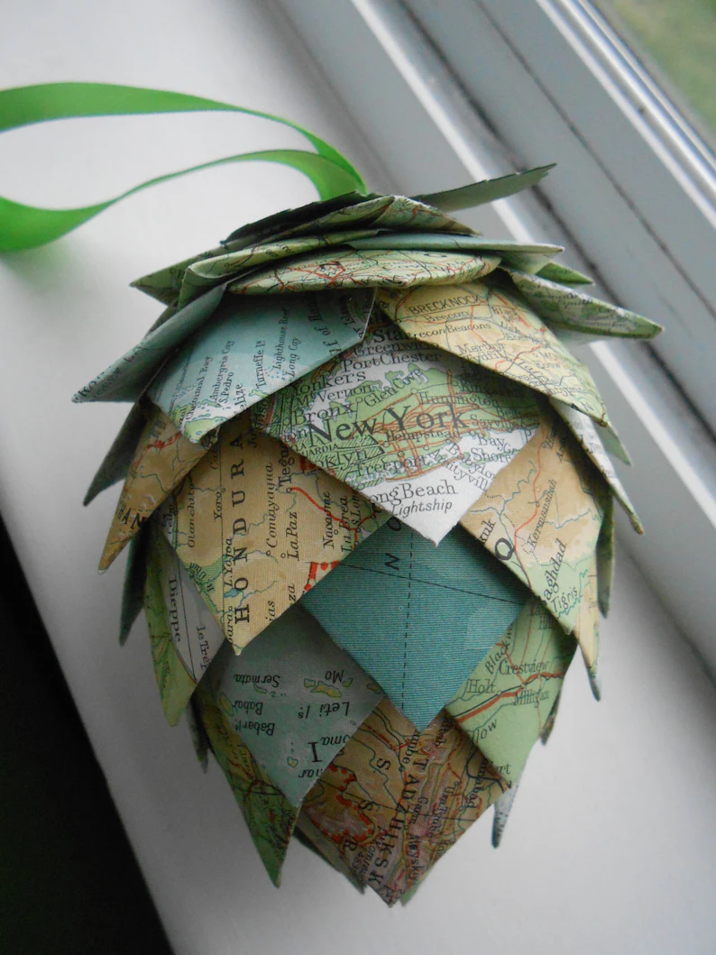 Picutre of completed craft.  Pine cone made of old book and map pages.