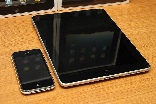 Image of an iPhone and iPad on a table.